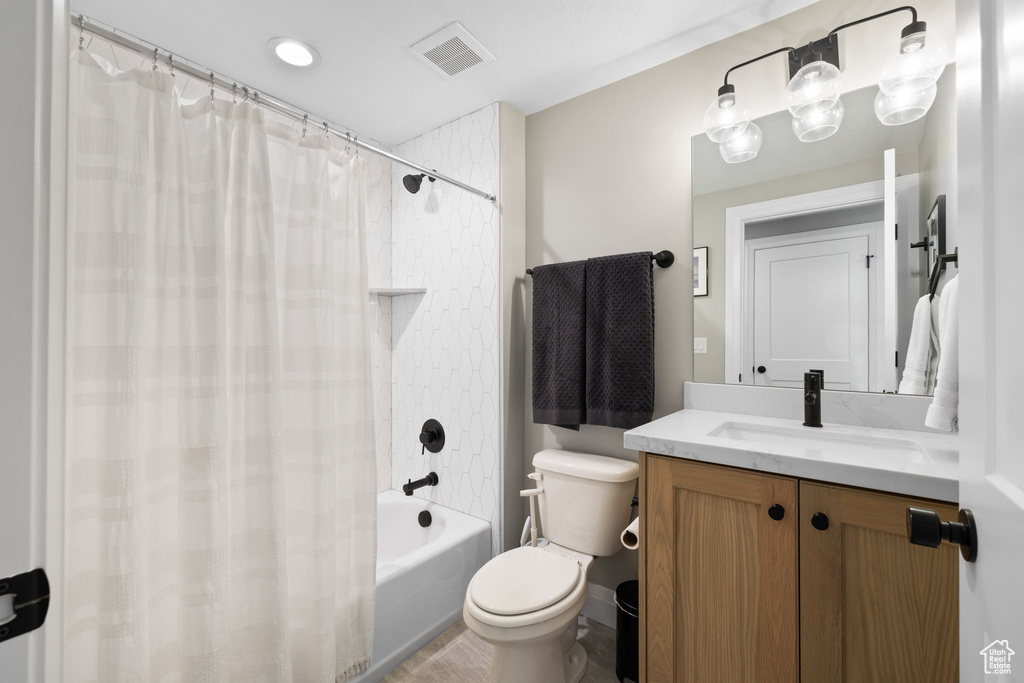 Full bathroom featuring vanity, toilet, and shower / tub combo