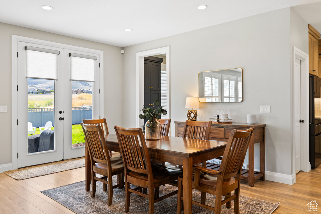 Dining room with french doors and light hardwood / wood-style flooring