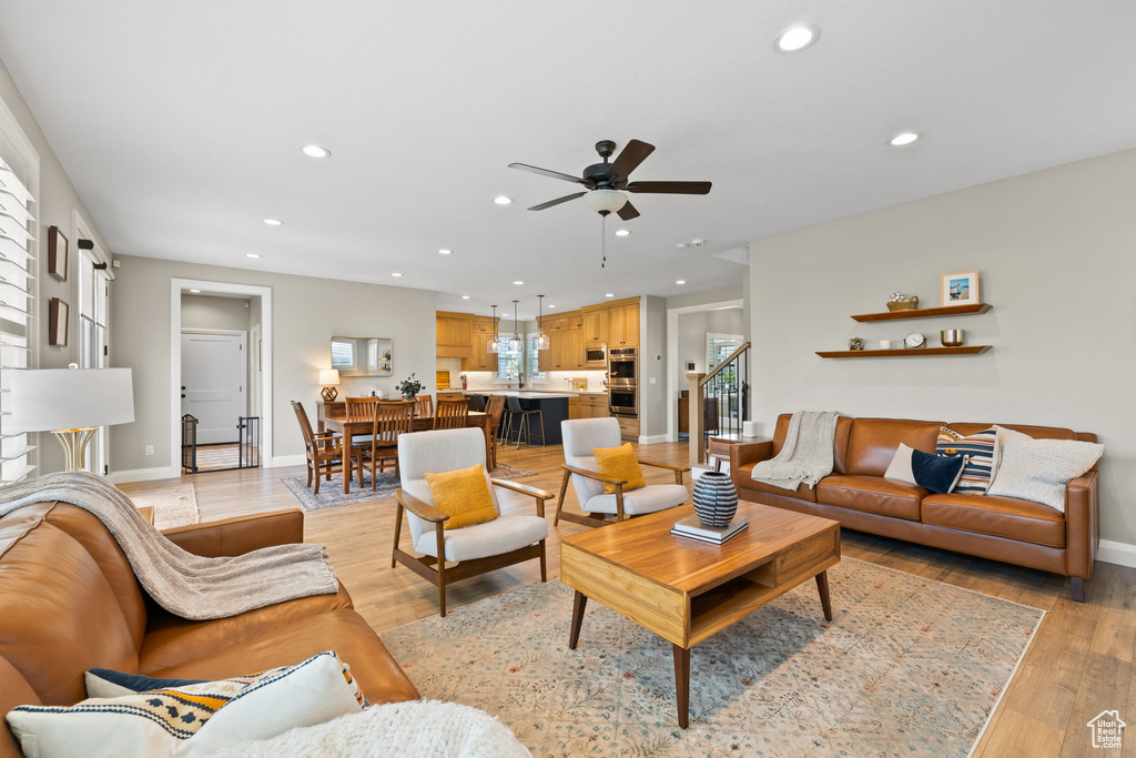 Living room with light wood-type flooring and ceiling fan