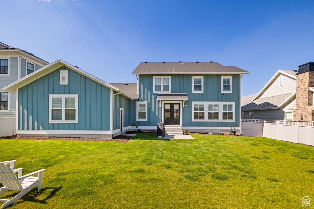 Rear view of house featuring a lawn