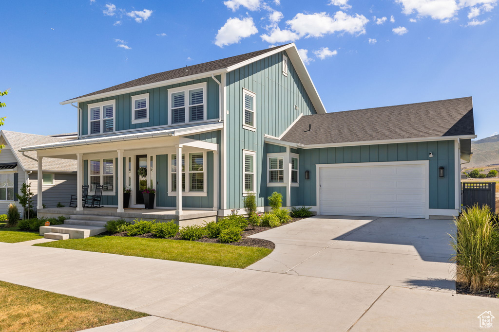 View of front of property with a porch and a garage