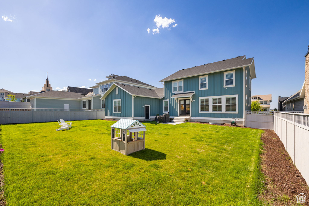 Rear view of property with a lawn