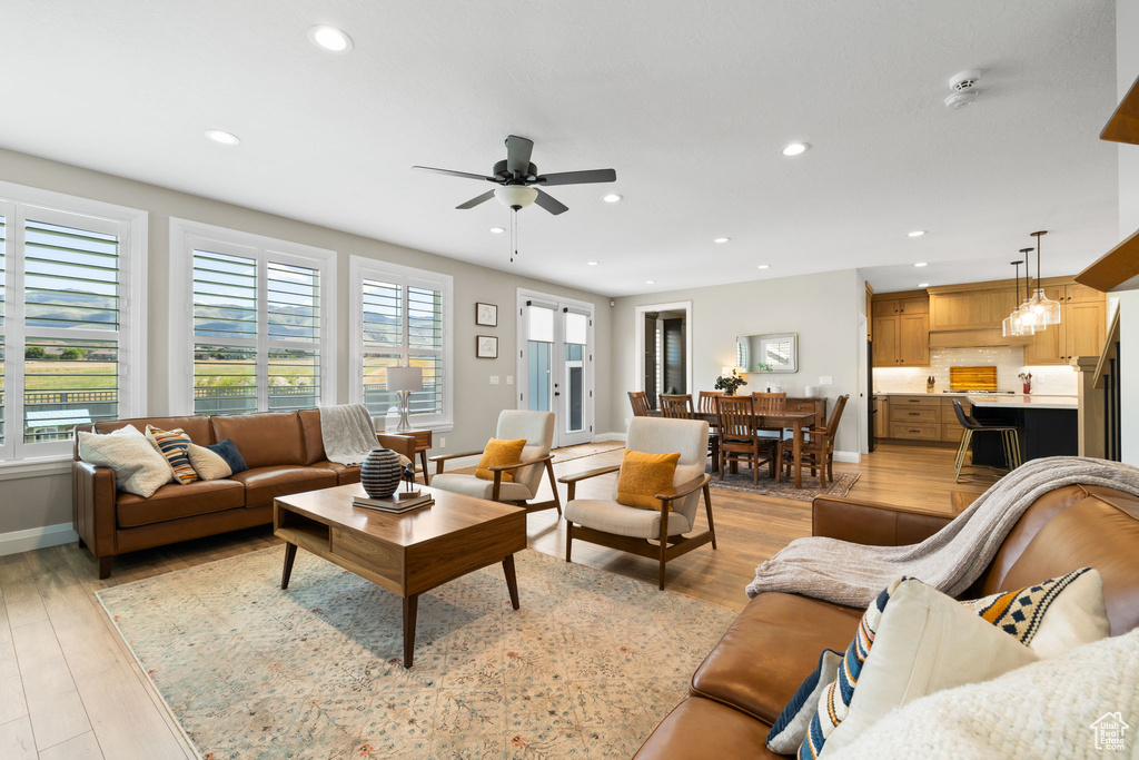 Living room with light wood-type flooring and ceiling fan