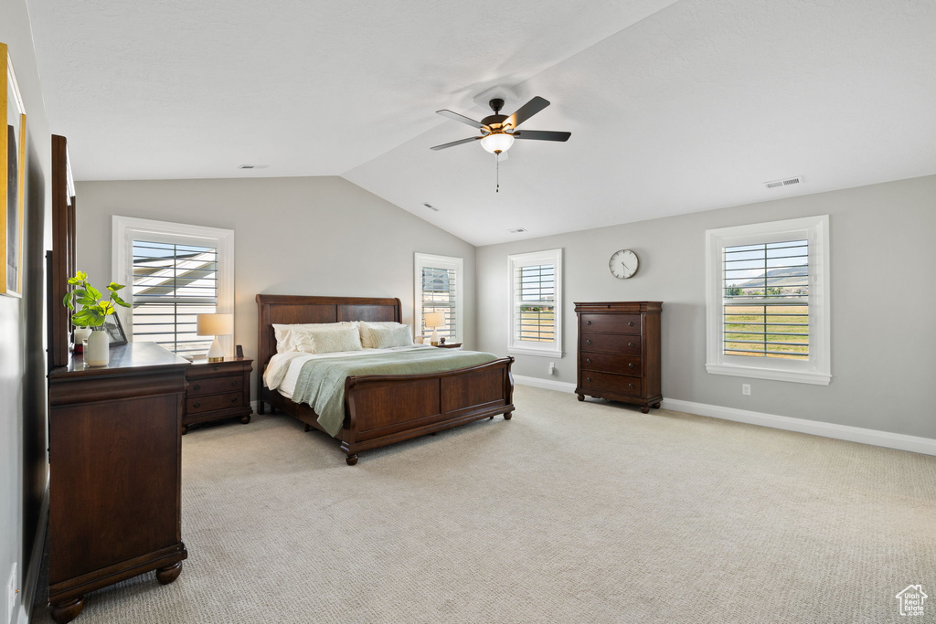 Carpeted bedroom featuring lofted ceiling and ceiling fan