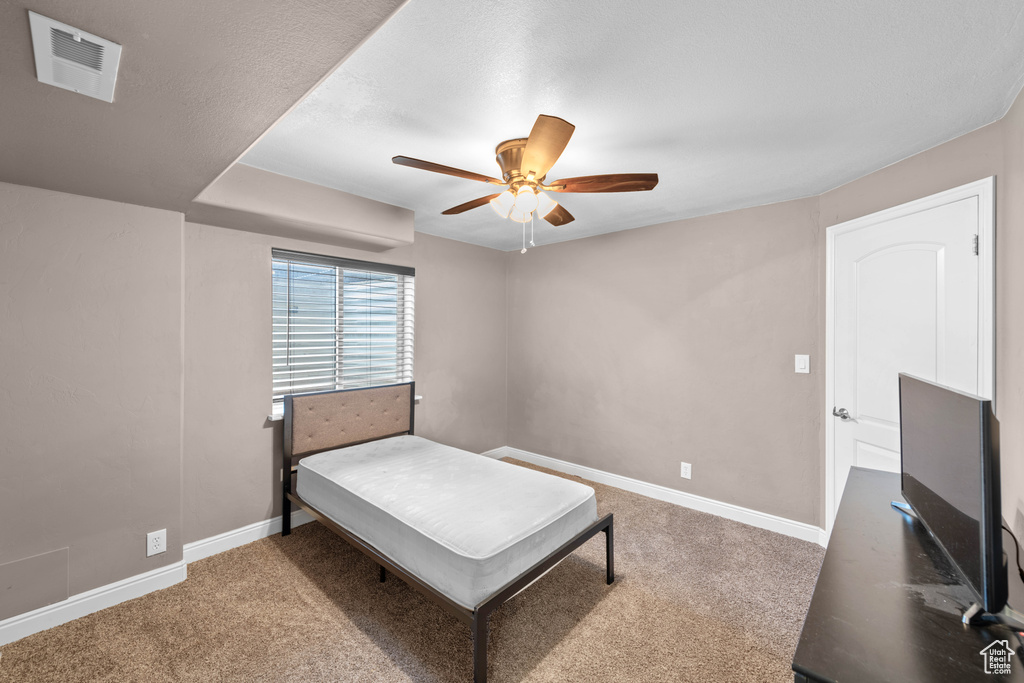 Carpeted bedroom featuring ceiling fan