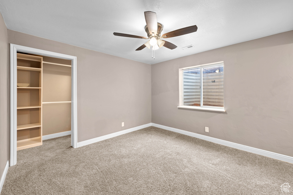 Unfurnished bedroom with light colored carpet, a closet, and ceiling fan