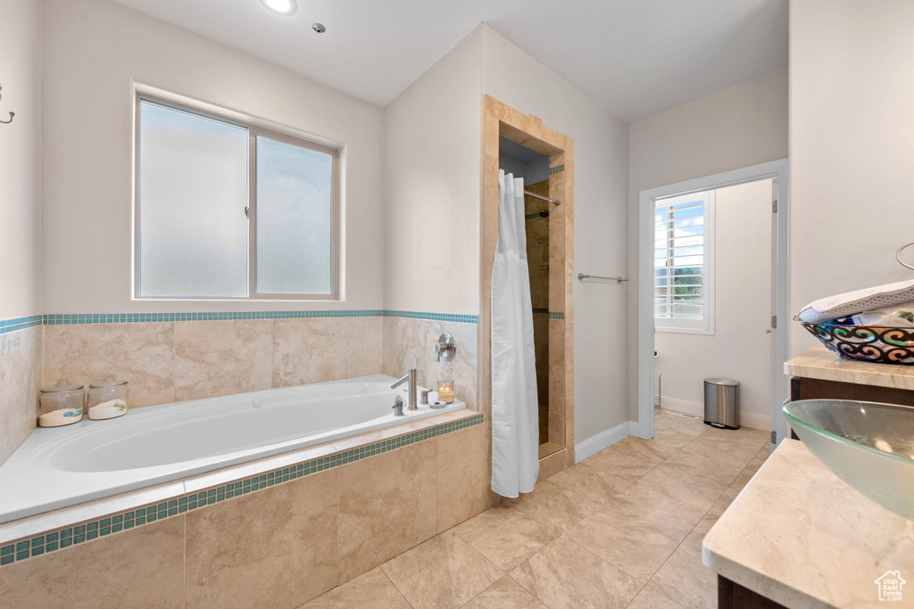 Bathroom with vanity, tiled bath, and tile patterned floors