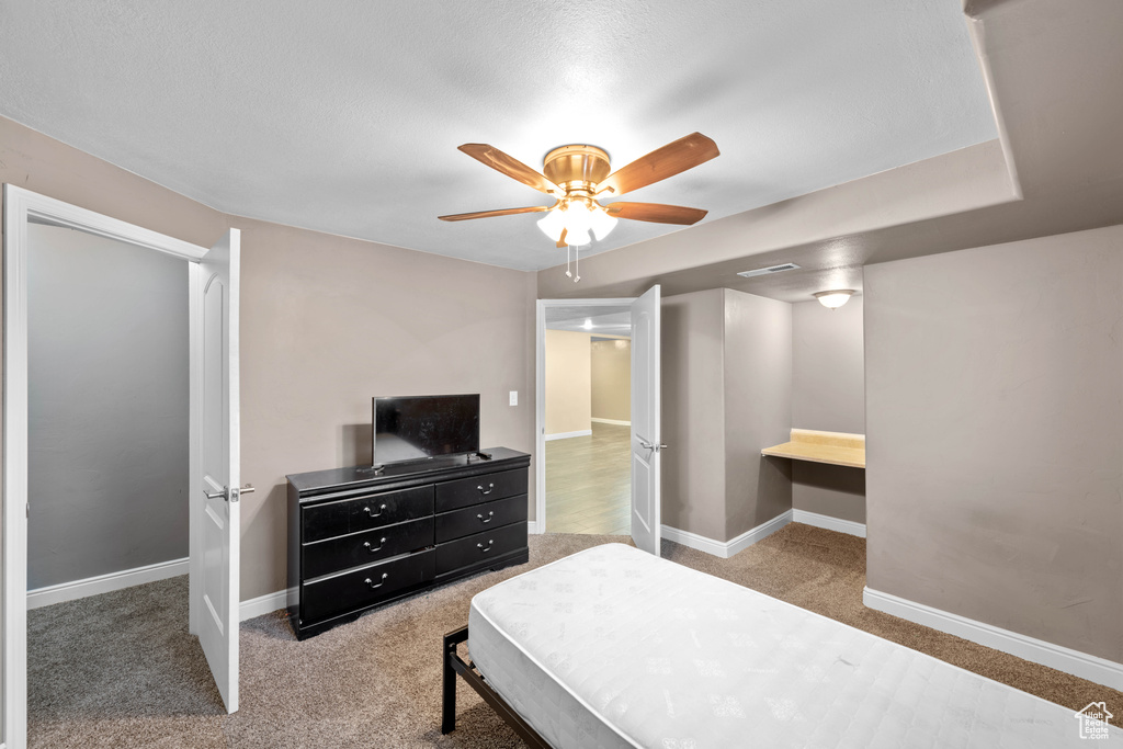 Carpeted bedroom with ceiling fan