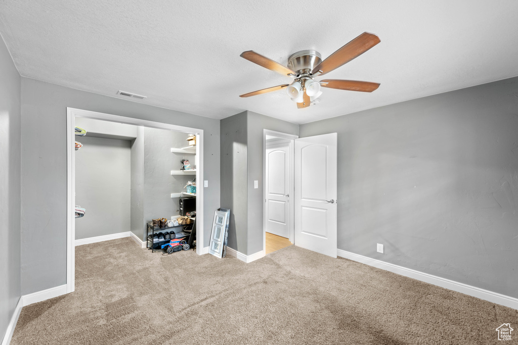 Unfurnished bedroom featuring light colored carpet, a closet, and ceiling fan