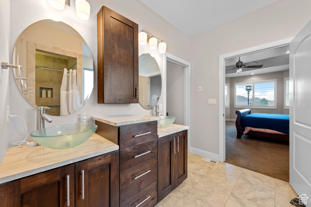 Bathroom featuring tile patterned flooring, ceiling fan, and dual bowl vanity