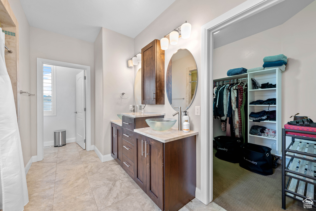 Bathroom featuring tile patterned flooring and dual bowl vanity