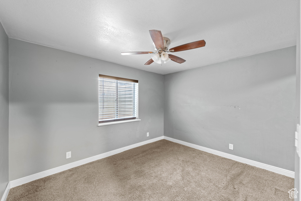 Carpeted spare room with ceiling fan