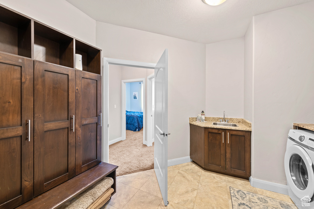 Laundry room featuring washer / clothes dryer, sink, and light tile patterned floors