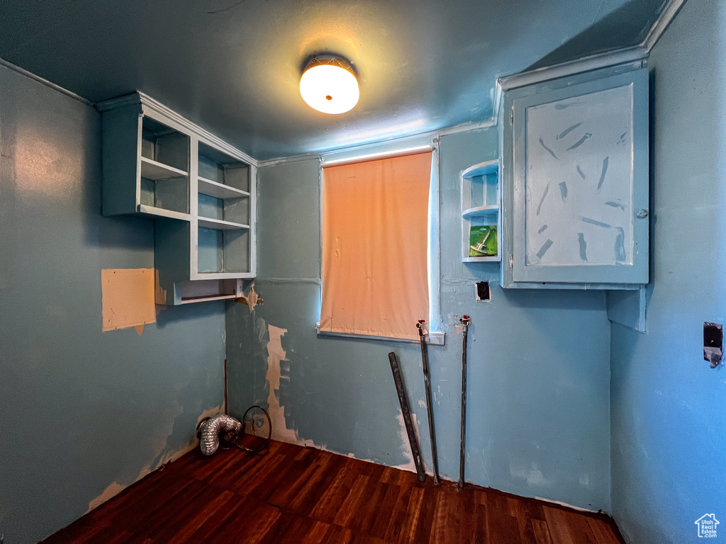 Clothes washing area with hardwood / wood-style floors