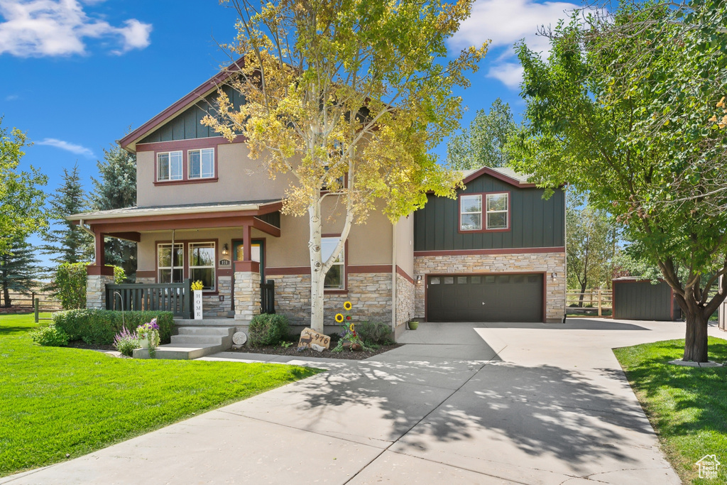 Craftsman-style house with a porch, a garage, and a front yard