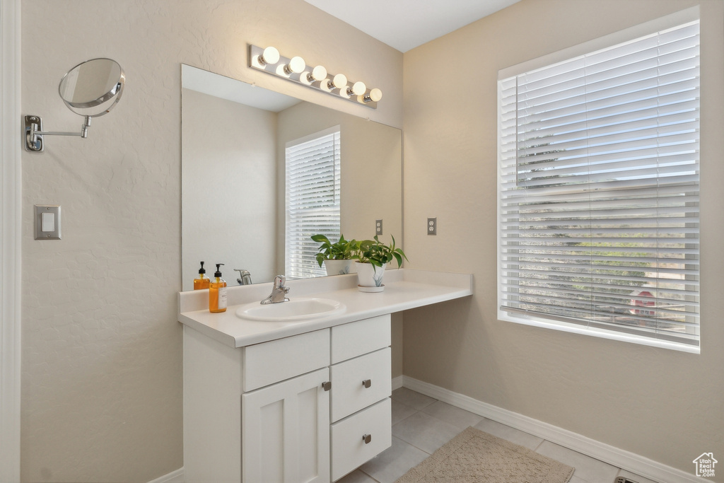 Bathroom featuring vanity, tile patterned floors, and plenty of natural light