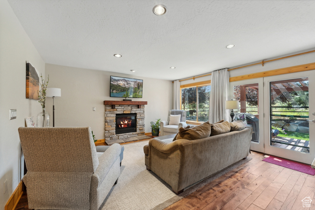 Living room with hardwood / wood-style flooring and a stone fireplace