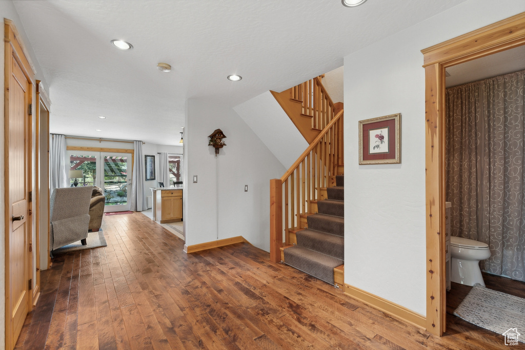 Staircase featuring hardwood / wood-style flooring