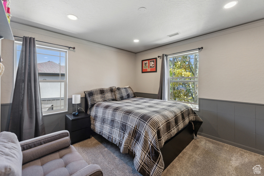 Carpeted bedroom with crown molding