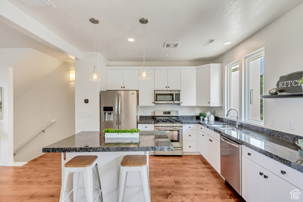 Kitchen featuring sink, stainless steel appliances, and white cabinetry