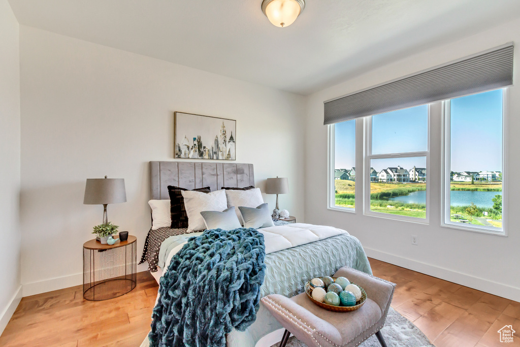 Bedroom featuring a water view and light hardwood / wood-style flooring