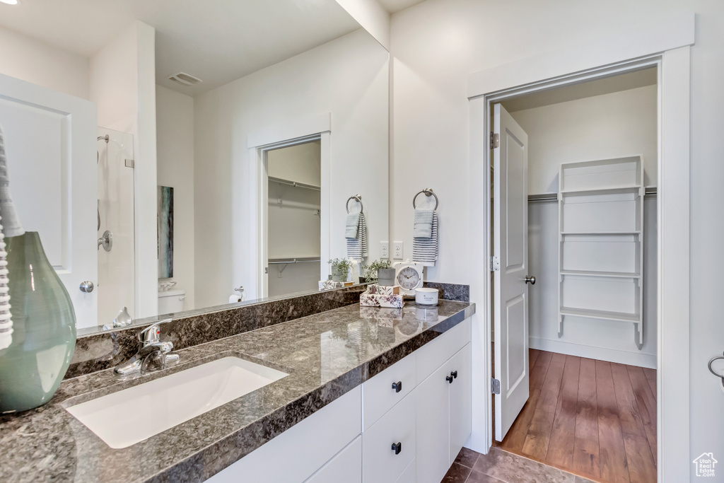 Bathroom with vanity, wood-type flooring, and walk in shower