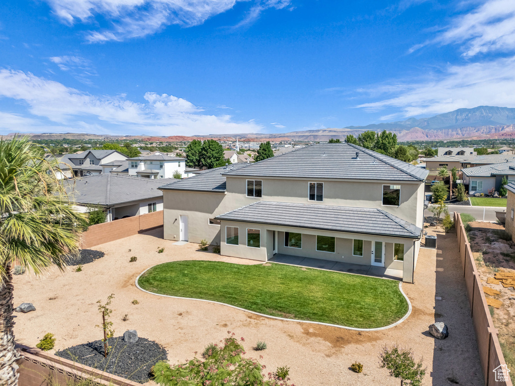 Rear view of house featuring a yard and a mountain view