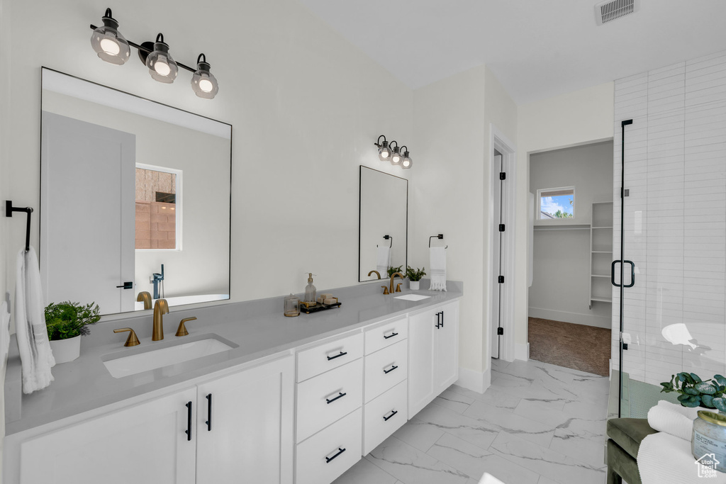 Bathroom featuring tile patterned flooring, an enclosed shower, and dual bowl vanity