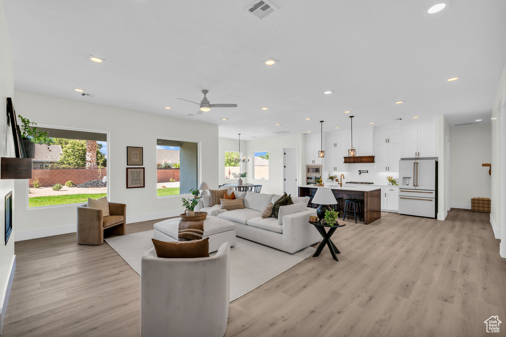 Living room featuring sink, ceiling fan, and light hardwood / wood-style floors