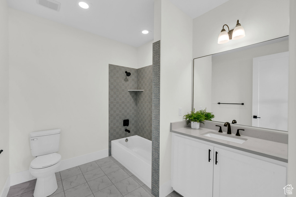 Full bathroom featuring tile patterned floors, vanity, tiled shower / bath, and toilet