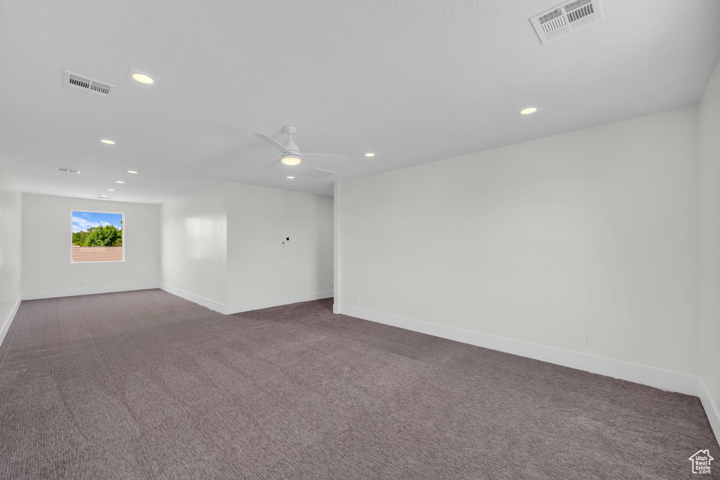 Carpeted empty room featuring ceiling fan