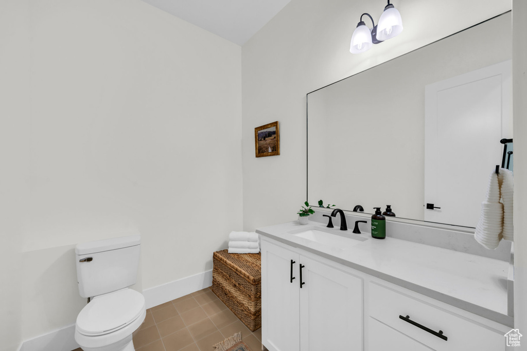 Bathroom featuring vanity, tile patterned flooring, and toilet