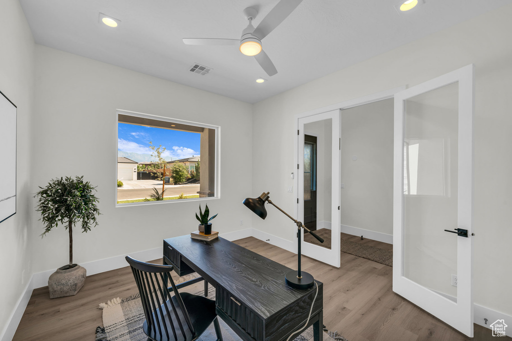 Office space featuring ceiling fan, french doors, and light hardwood / wood-style flooring