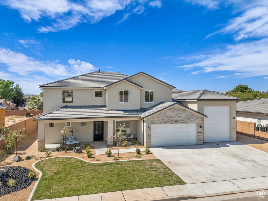 View of front property with a garage and a front lawn