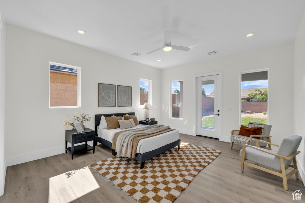 Bedroom featuring ceiling fan, access to outside, light hardwood / wood-style flooring, and multiple windows