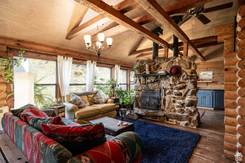 Living room featuring dark wood-type flooring, vaulted ceiling with beams, a fireplace, and rustic walls