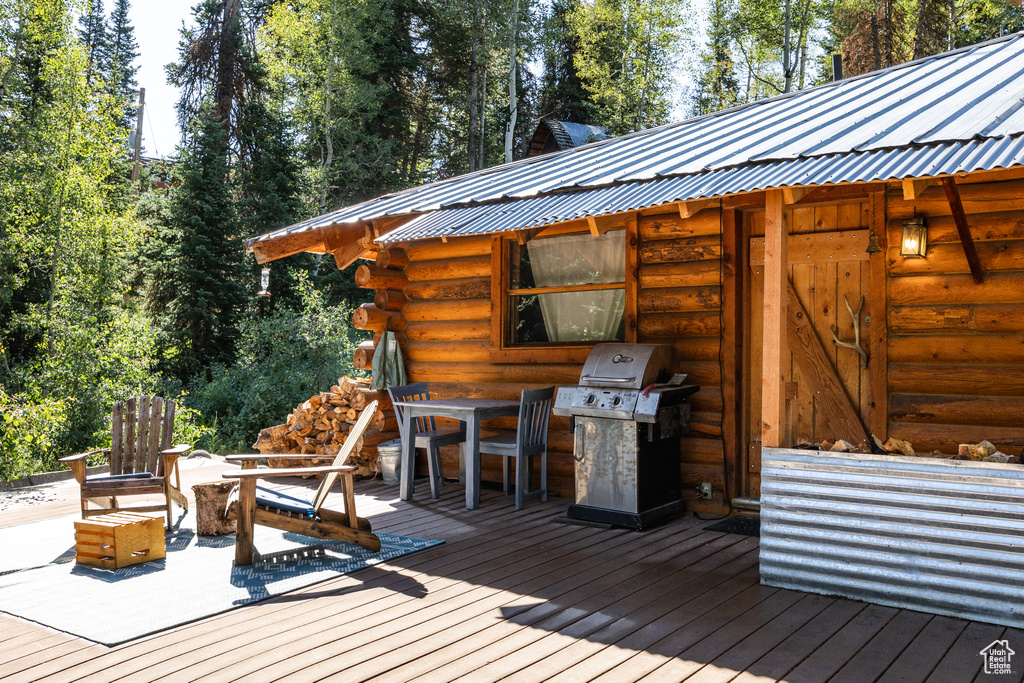 Wooden terrace with an outdoor fire pit and a grill