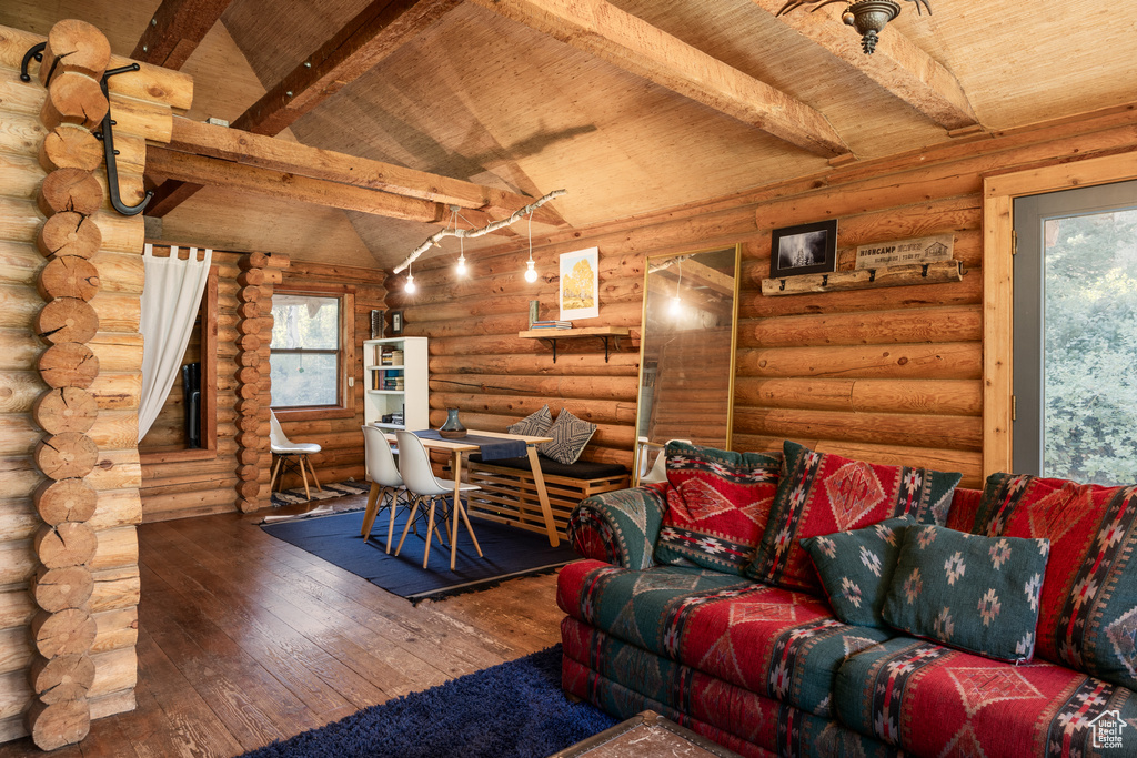 Living room with wood-type flooring, vaulted ceiling with beams, log walls, and wooden ceiling