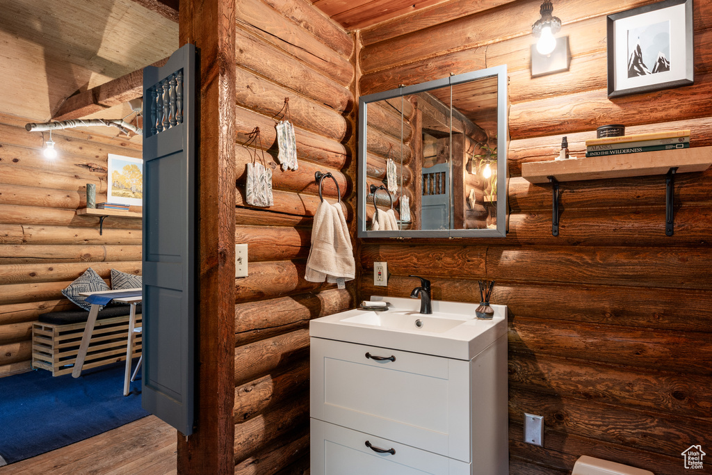 Bathroom with vanity, wood-type flooring, wooden ceiling, and log walls