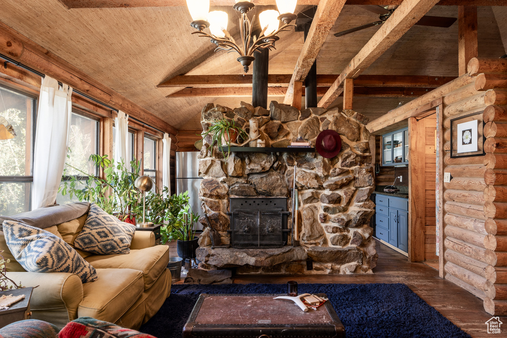 Living room featuring wood ceiling, a stone fireplace, rustic walls, a chandelier, and hardwood / wood-style flooring