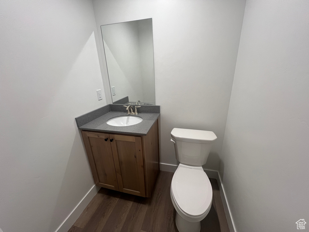 Bathroom with toilet, hardwood / wood-style floors, and vanity