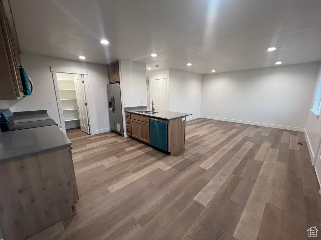 Kitchen featuring sink, wood-type flooring, kitchen peninsula, and stainless steel appliances