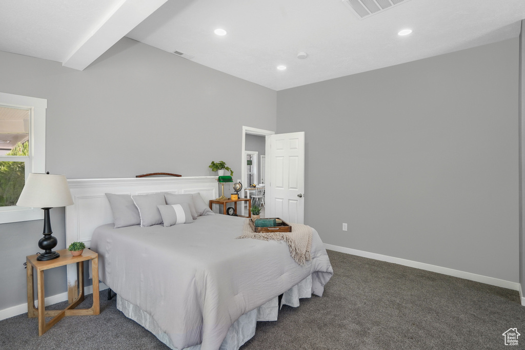 Carpeted bedroom featuring beamed ceiling