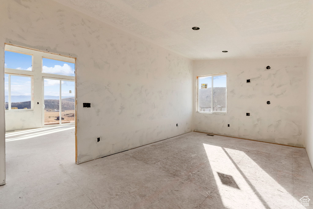 Spare room featuring a mountain view and lofted ceiling