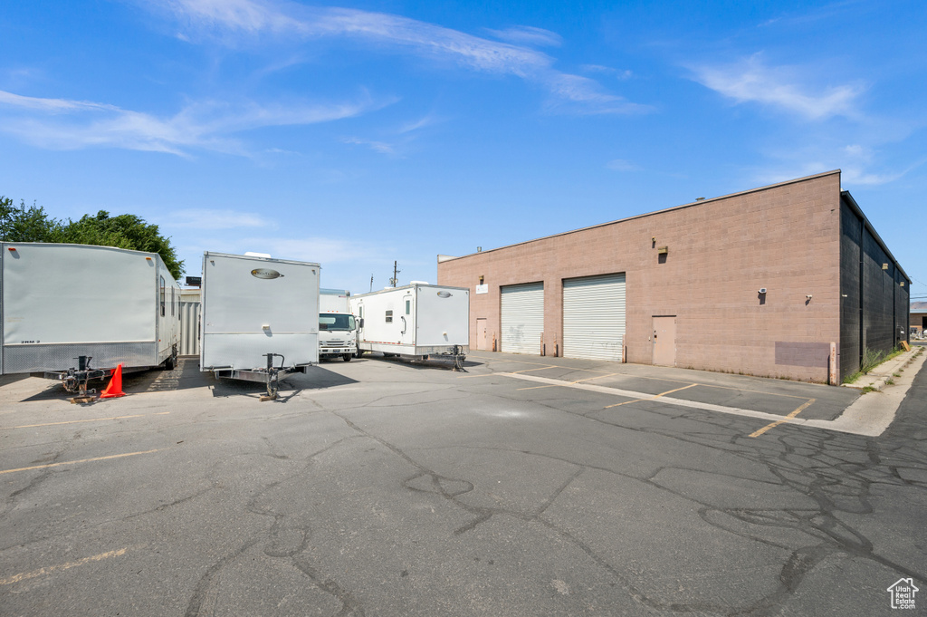 View of parking / parking lot featuring a garage