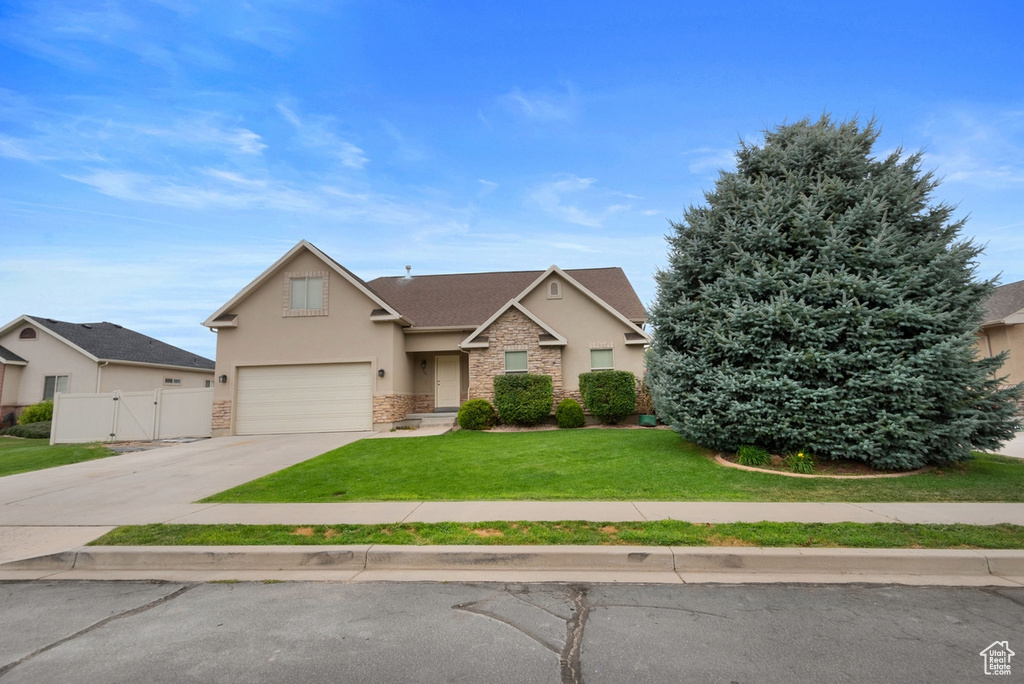 View of front of house featuring a garage and a front yard