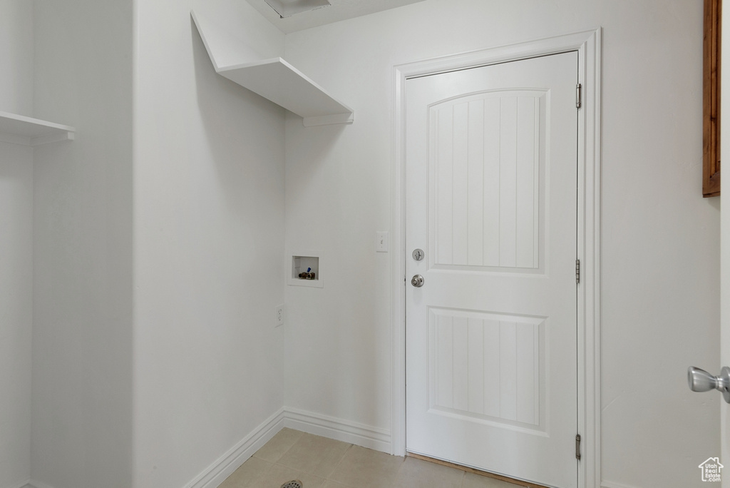 Laundry area with hookup for a washing machine and light tile patterned floors