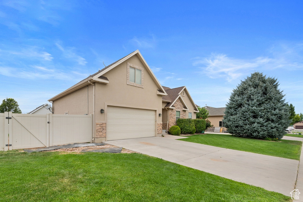 View of front of house featuring a garage and a front yard