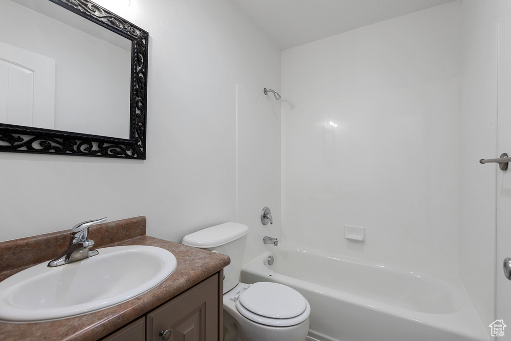 Full bathroom featuring toilet, vanity, and shower / tub combination