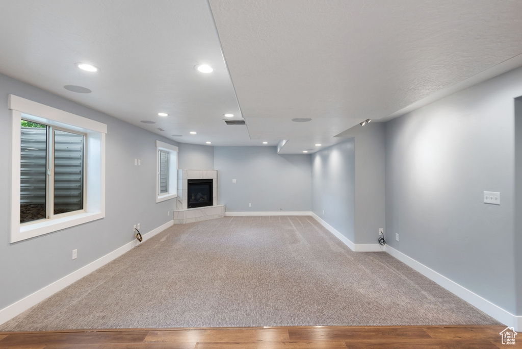 Basement featuring light colored carpet and a tile fireplace